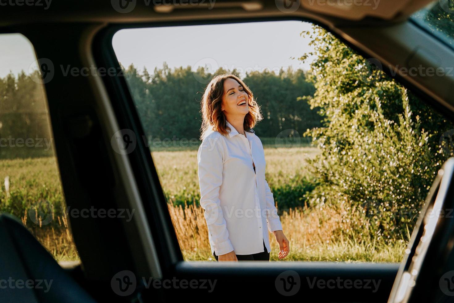 een mooie jonge vrouw in een wit overhemd rust buiten de stad foto