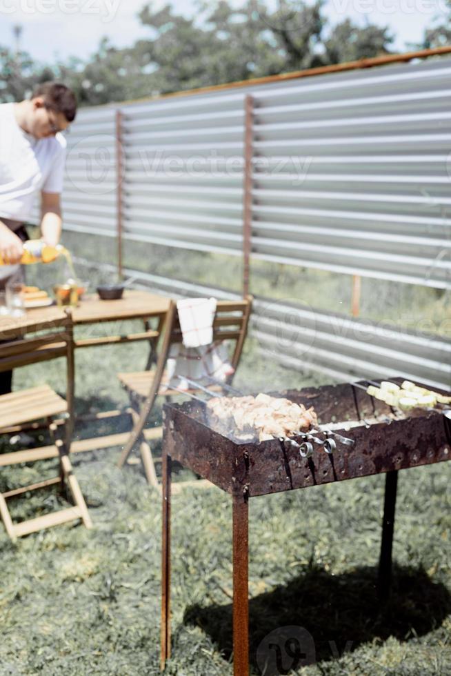 man grillen kebab op spiesjes foto