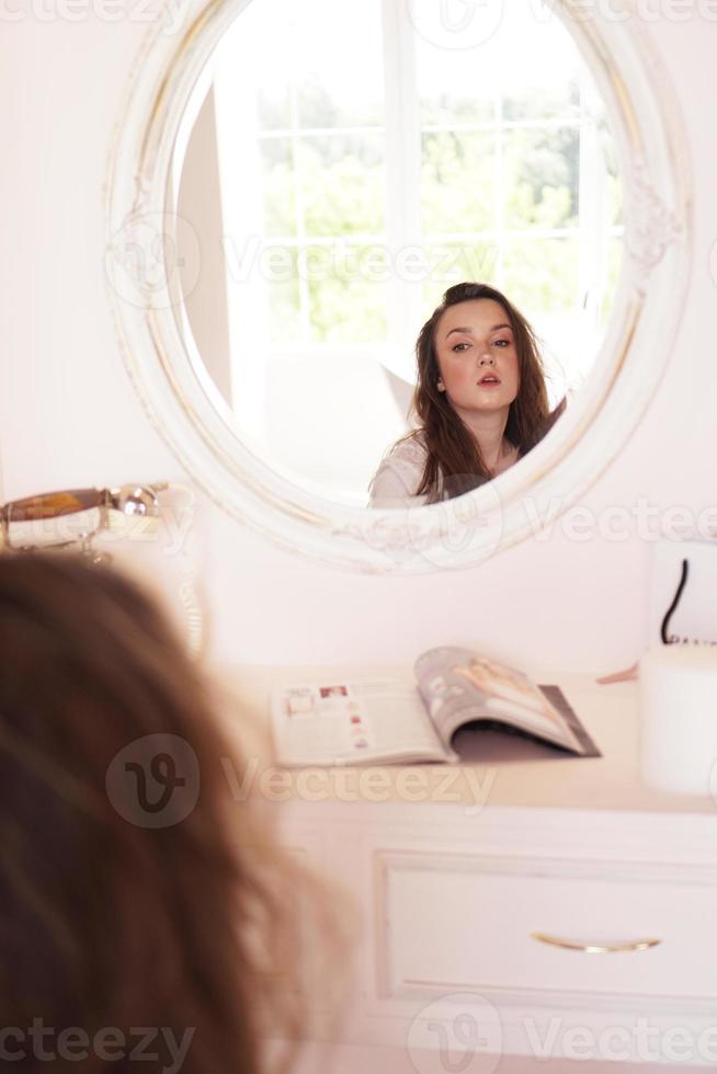 gelukkige vrouw in haar kamer bij haar kaptafel poseren voor het feest foto