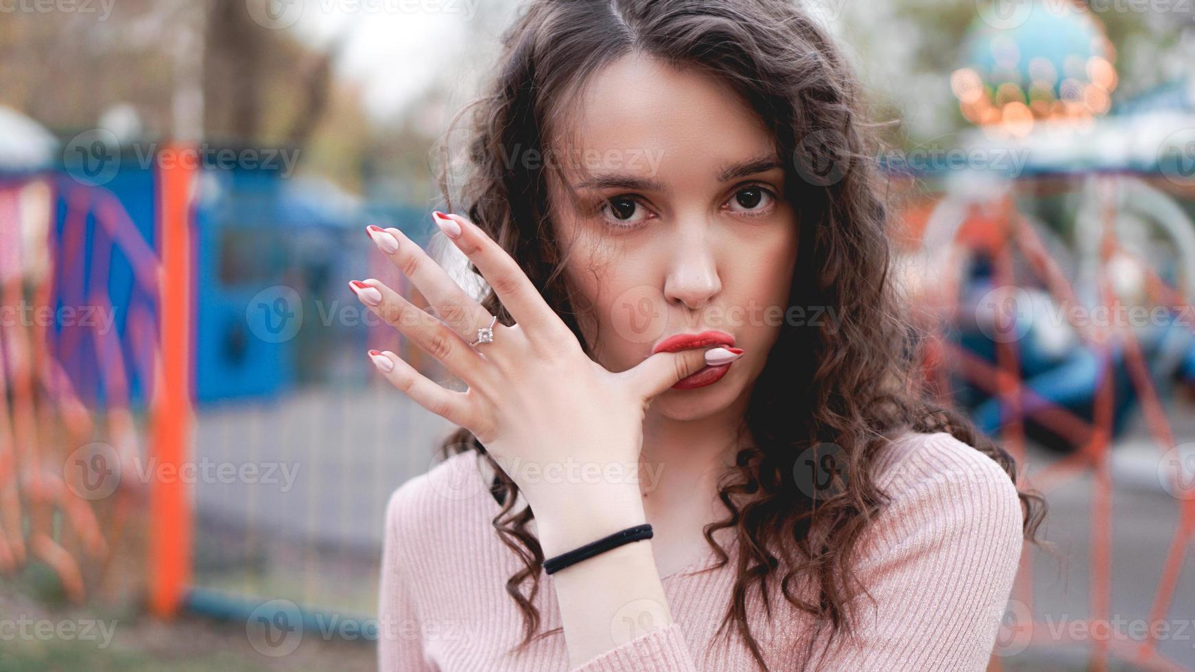 jonge hipster vrouw poseren buitenshuis op de achtergrond van carrousels foto