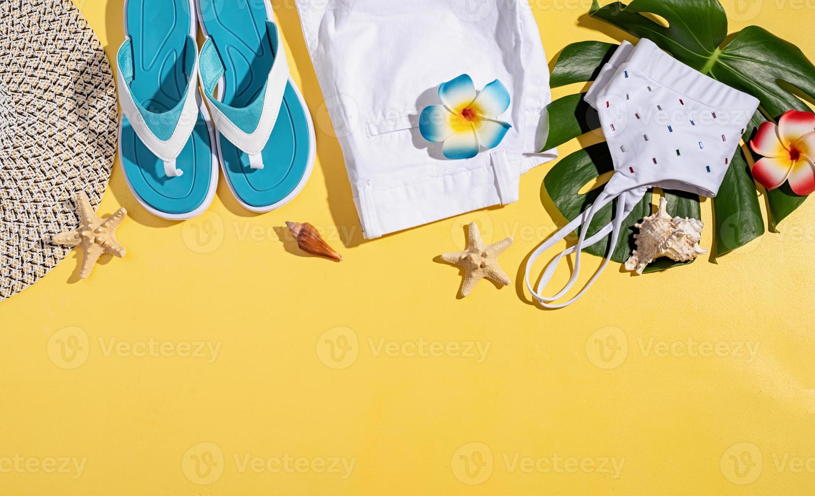 zomeraccessoires met kleding, schoenen, tropische bladeren en bloemen foto