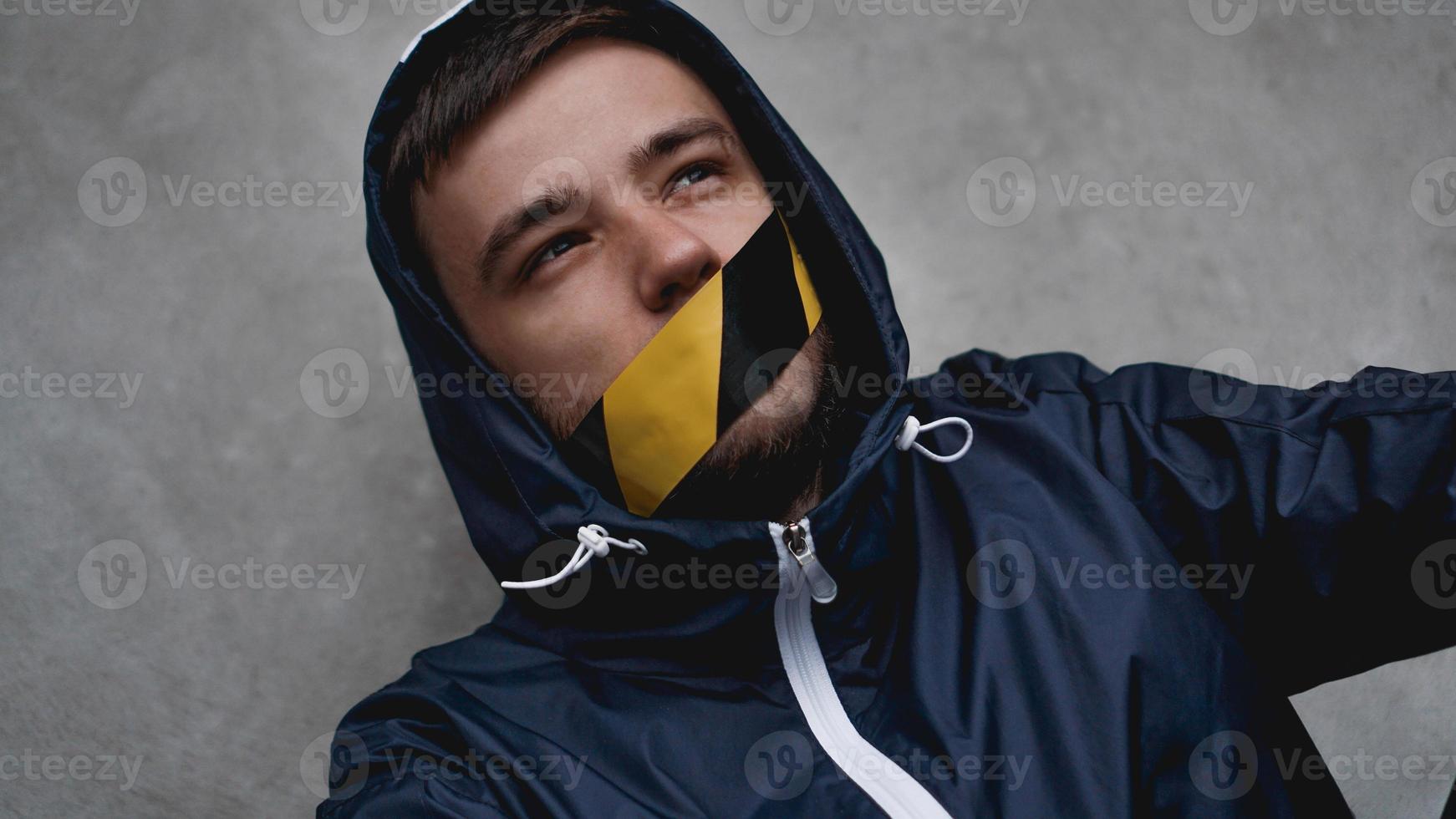 man met tape over zijn mond foto
