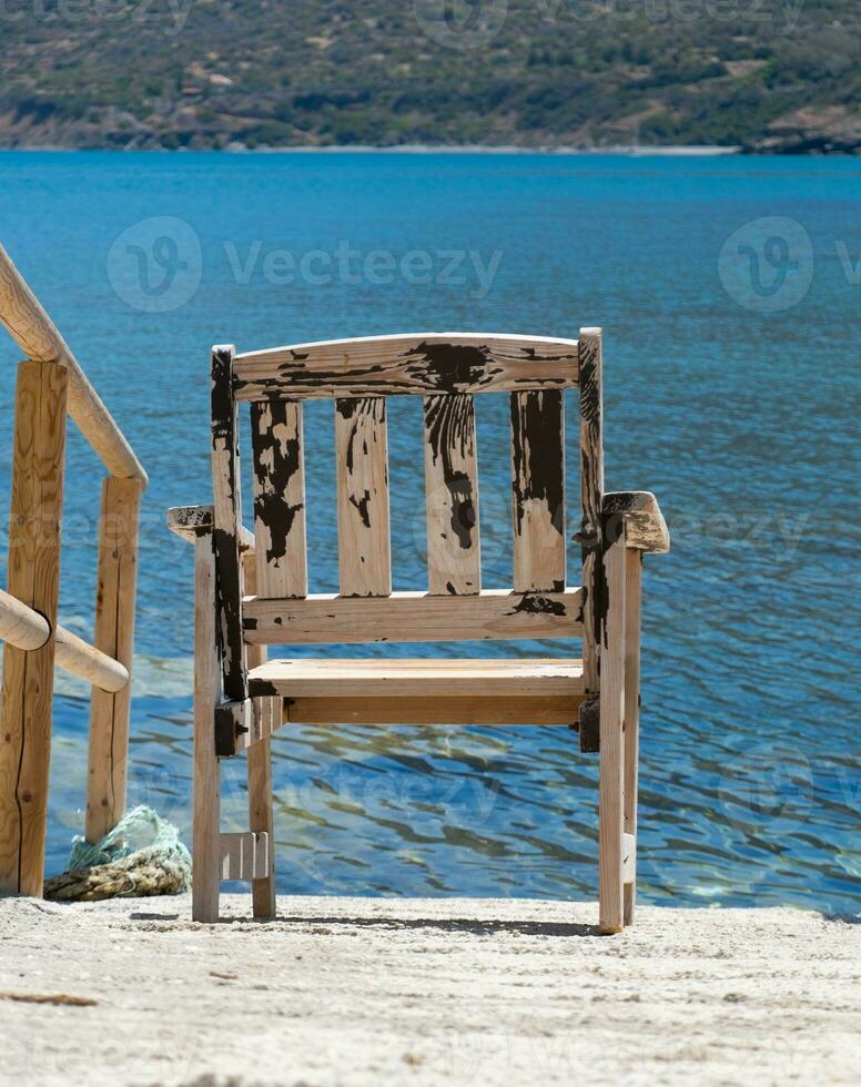 houten stoel met uitzicht de blauw zee Bij pomos haven, eiland van Cyprus foto