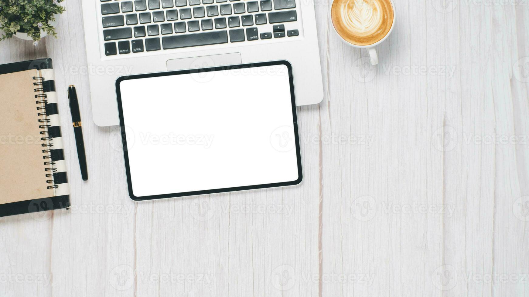 wit houten bureau werkplaats met blanco scherm tablet, laptop, pen, notitieboekje en kop van koffie, top visie vlak leggen met kopiëren ruimte. foto