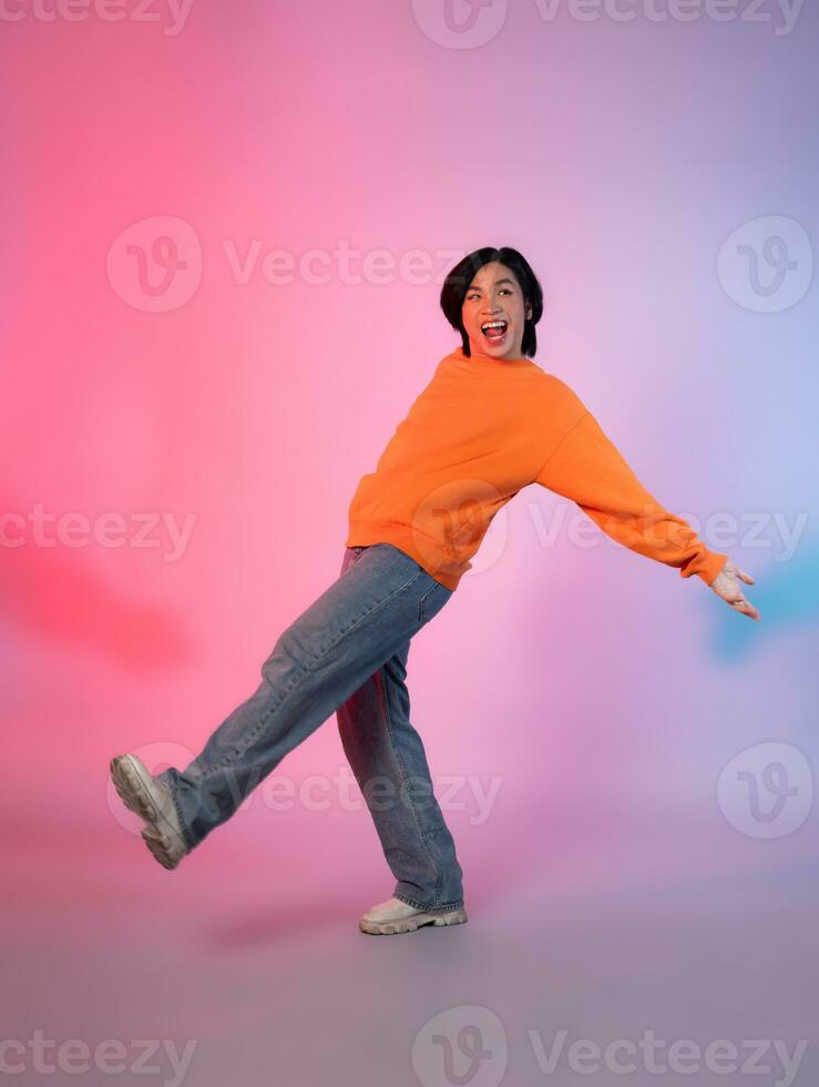 beeld van een jong Aziatisch persoon dansen Aan een neon gekleurde achtergrond foto