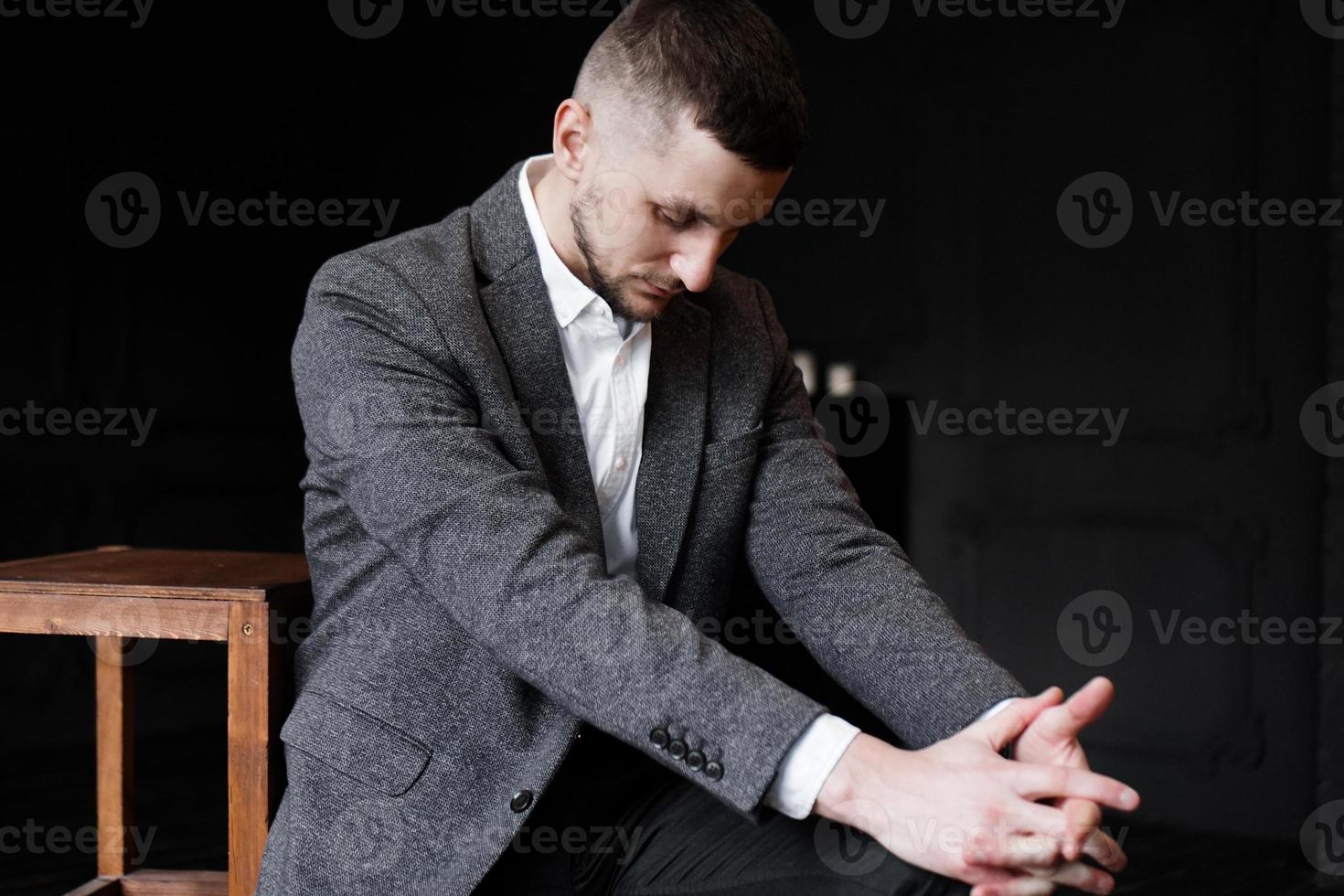 portret van een succesvolle zakenman in een formeel pak die naar beneden kijkt foto