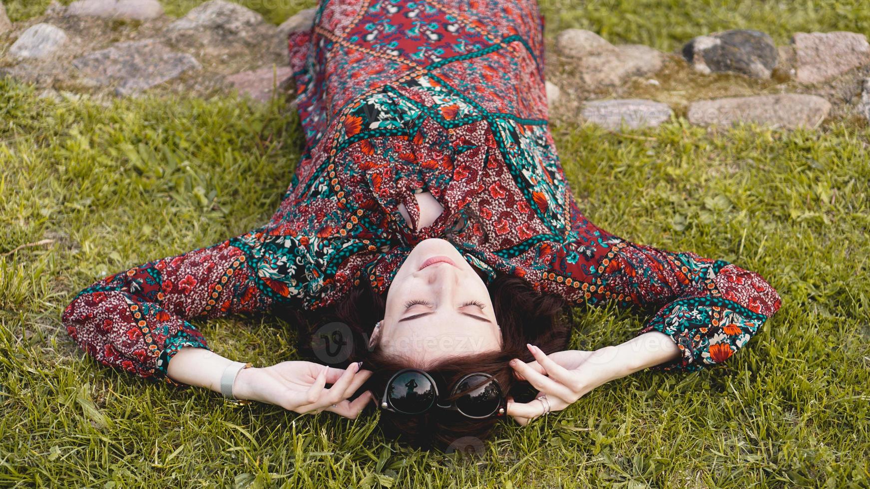 jonge vrouw liggend op het gras. mensen ontspannen in de buitenlucht. foto