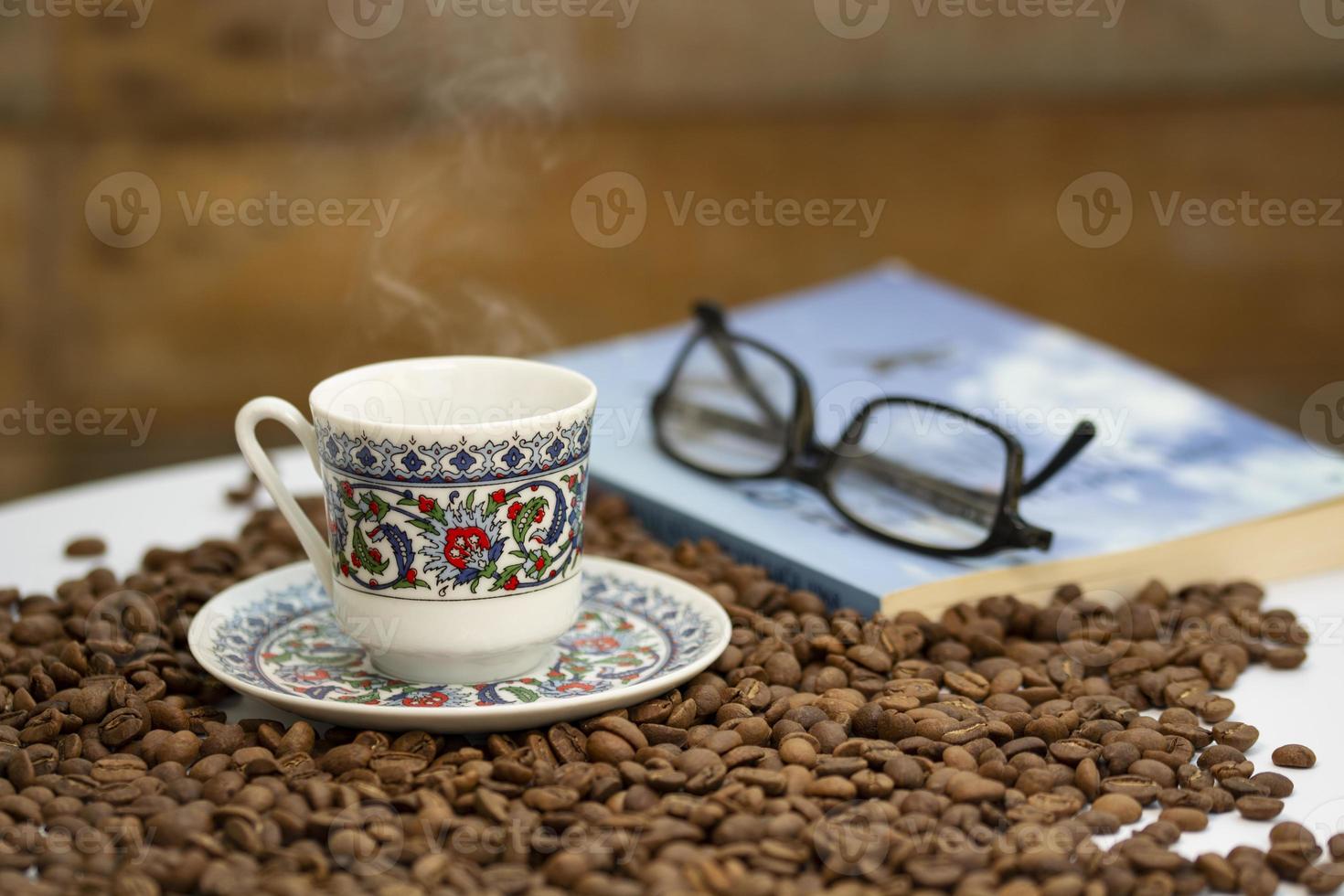 koffiebonen, turkse koffiekop en een boekenrek op tafel foto