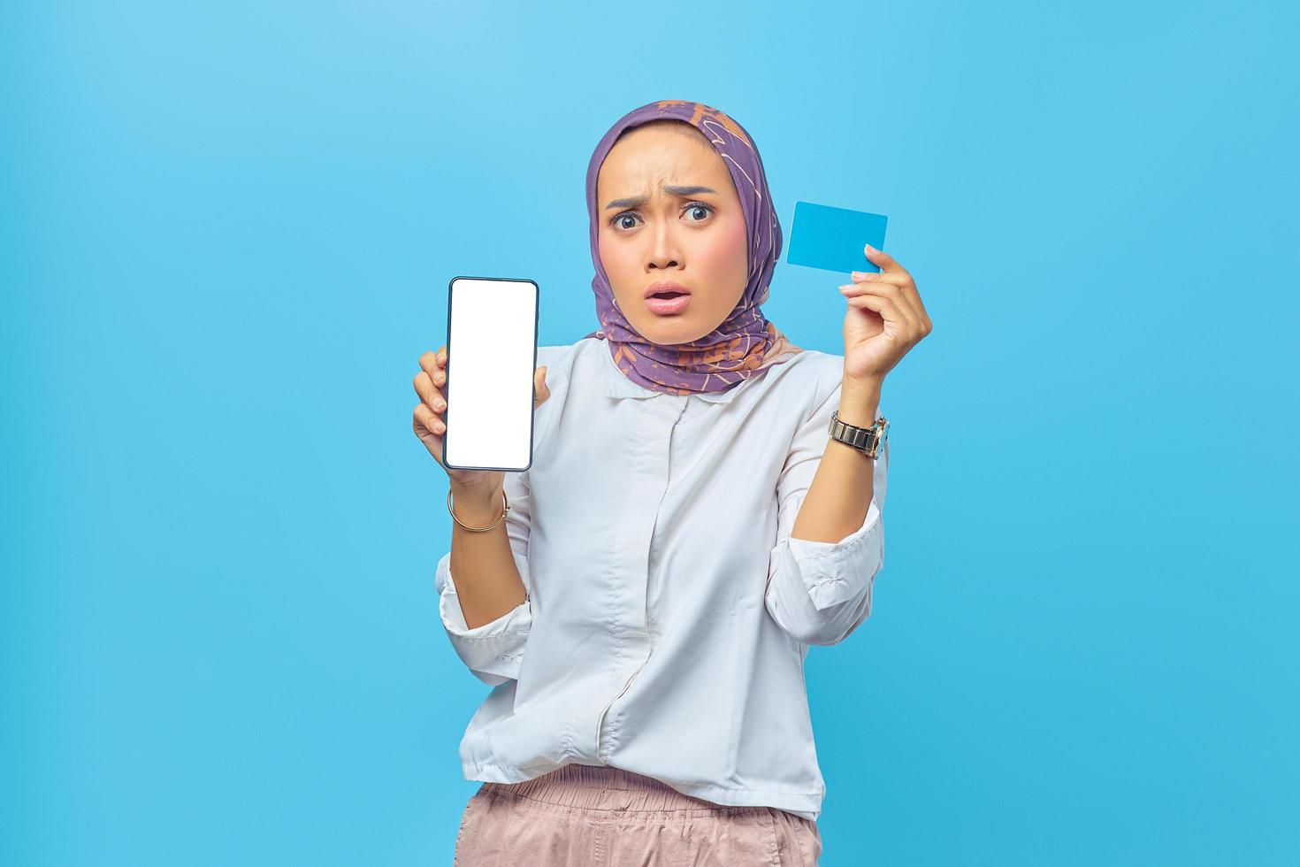 portret van geschokte aziatische vrouw met creditcard en smartphone foto