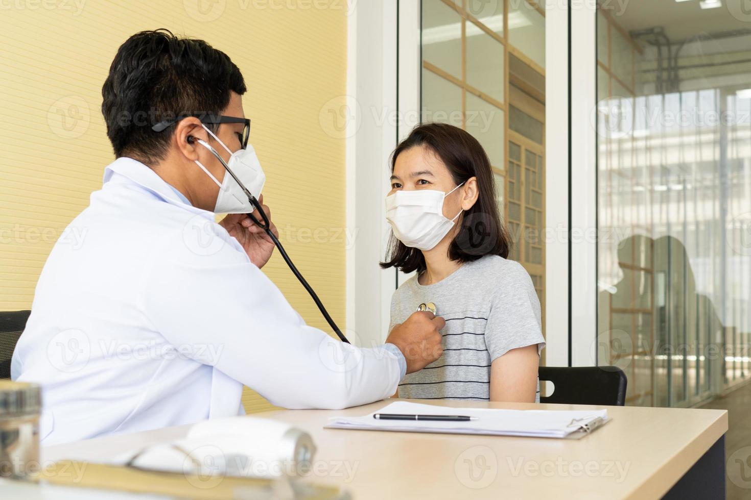 arts die patiënt een check-up geeft met maskers op foto
