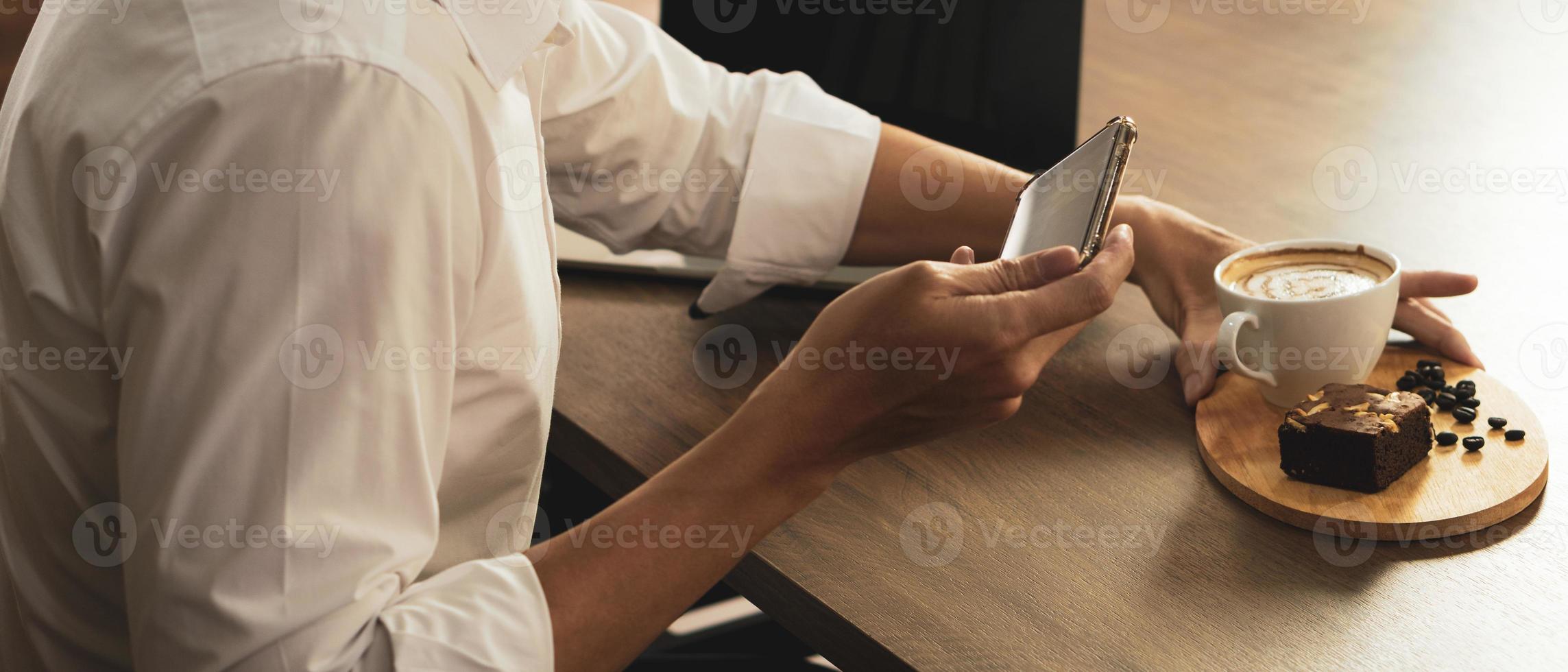 zakenman die smartphone gebruikt om foto's te maken van koffie in café foto