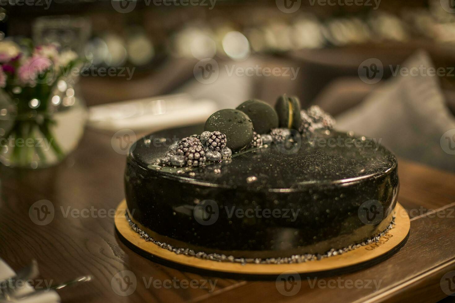 zwart chocola taart Aan een houten tafel. versierd met chocola spaander koekjes verjaardag taart Aan een restaurant foto