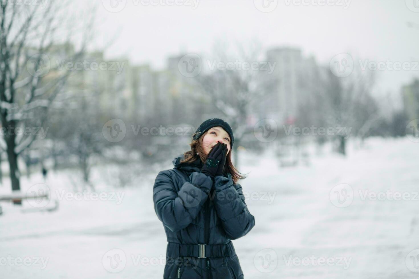 de meisje is opwarming haar handen in voorkant van haar gezicht. foto