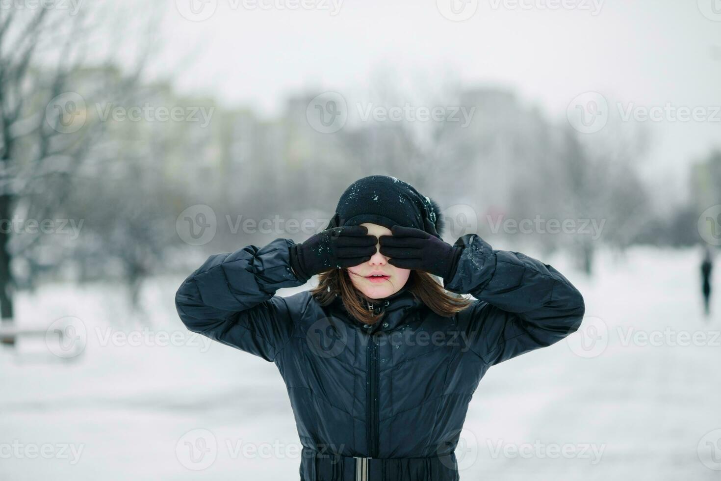 meisje decennium Gesloten ogen met handst achtergrond van winter landschap. kind doet niet willen naar Look. foto