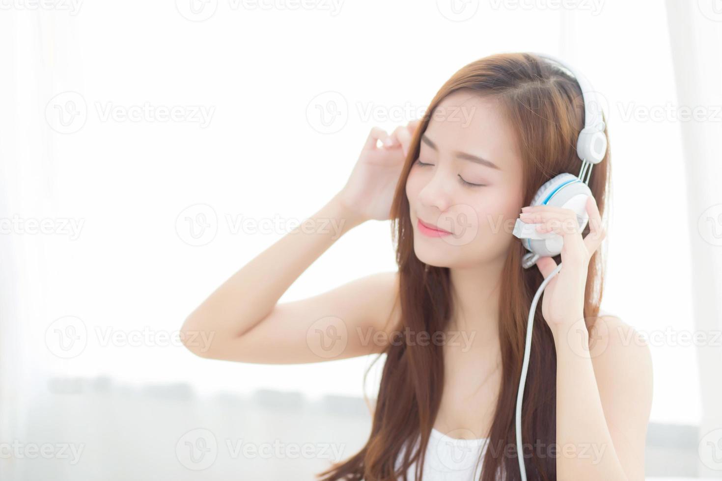 jonge aziatische vrouw geniet van muziek luisteren met een koptelefoon. foto