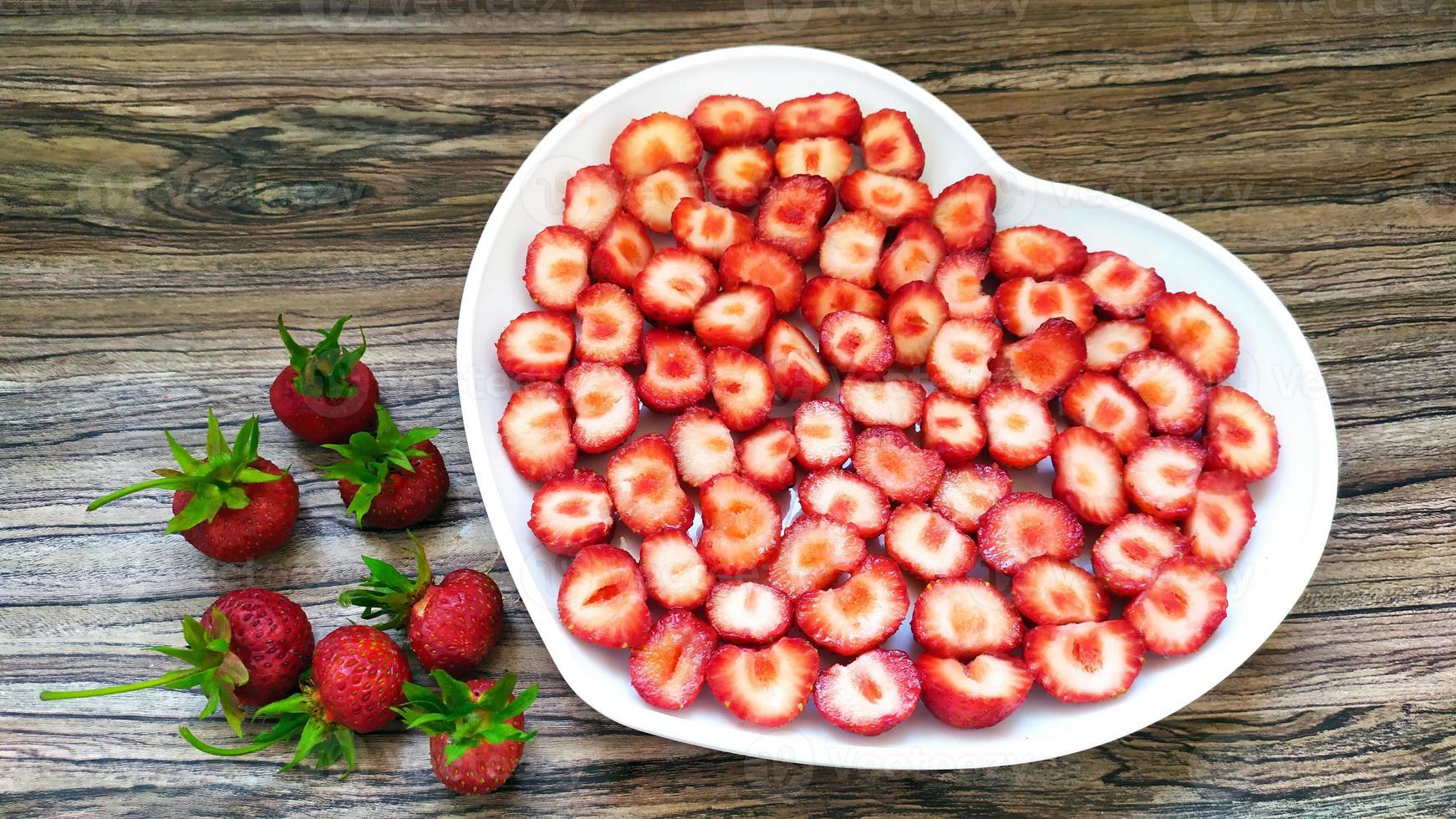 aardbeien in een witte plaat met een hart. een romantische portie foto