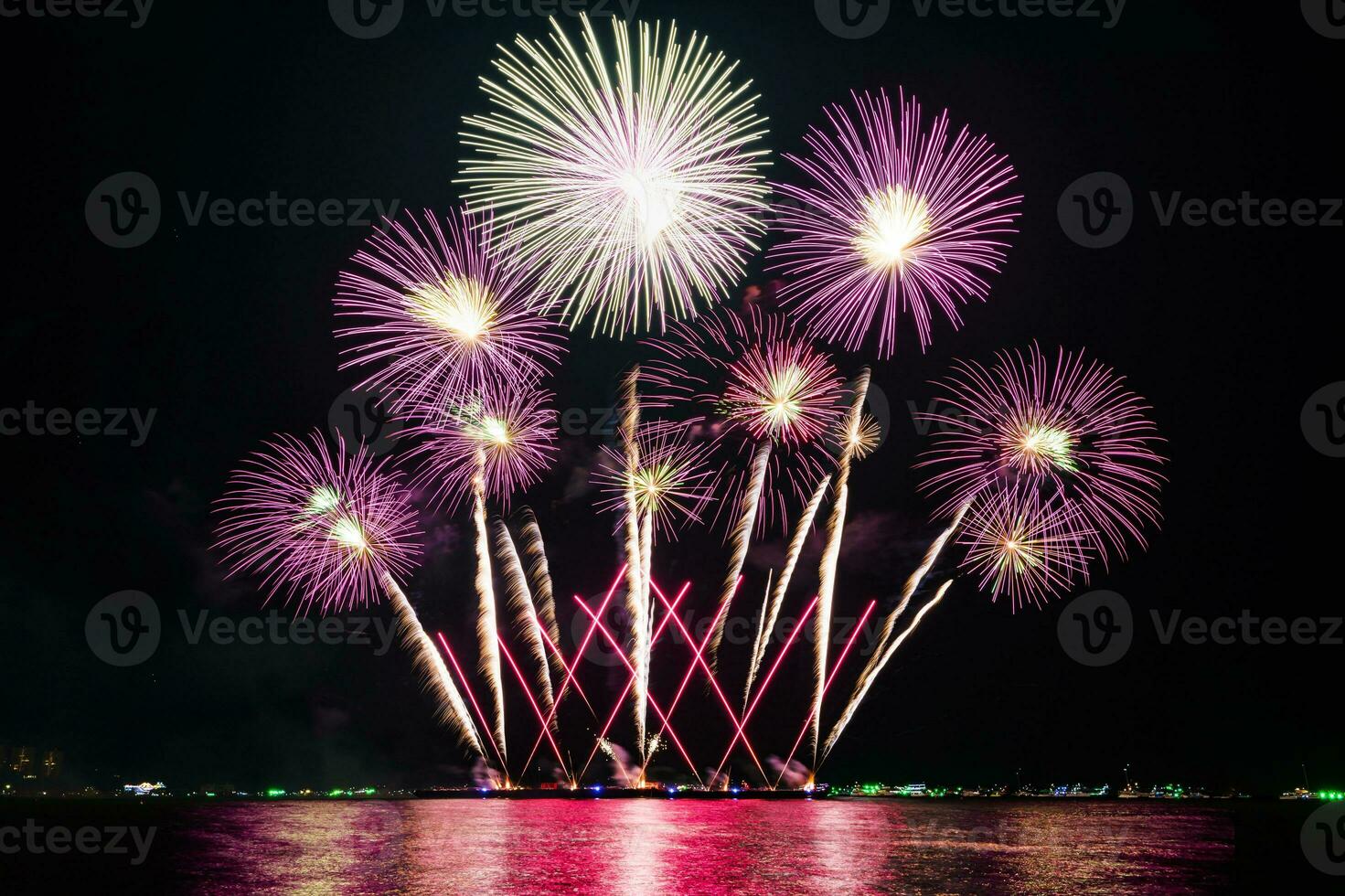 geweldig mooi kleurrijk vuurwerk op de feestavond, te zien op het zeestrand met veelkleurige reflectie op water foto