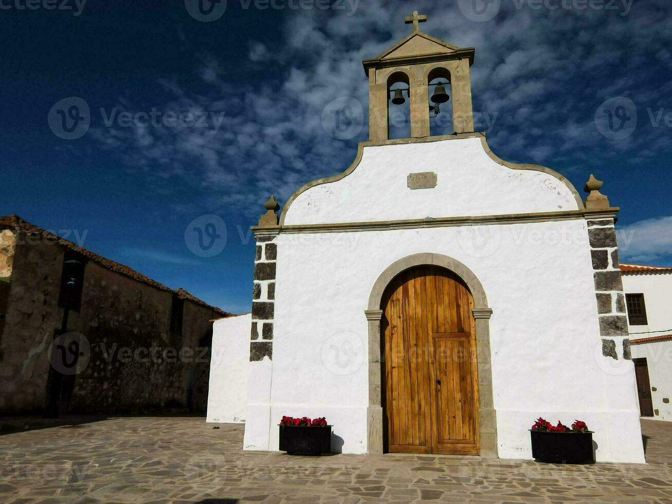 een klein wit kerk met een houten deur foto