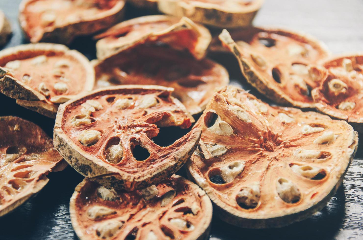 gedroogde kruiden en gedroogd baelfruit, plakjes baelfruit op tafel. foto