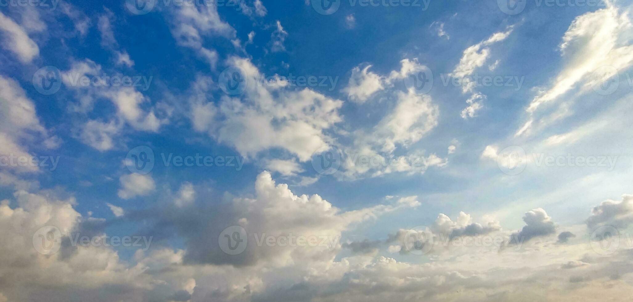 een blauw lucht met wolken en een weinig wolken, blauw lucht, wit wolk tijd vervallen van wolken in de lucht, de zon schijnt door de wolken in deze foto, dramatisch lucht wolken foto