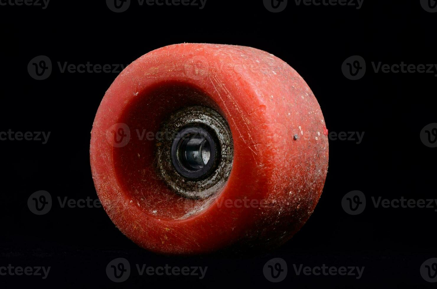 een rood skateboard wiel Aan een zwart achtergrond foto