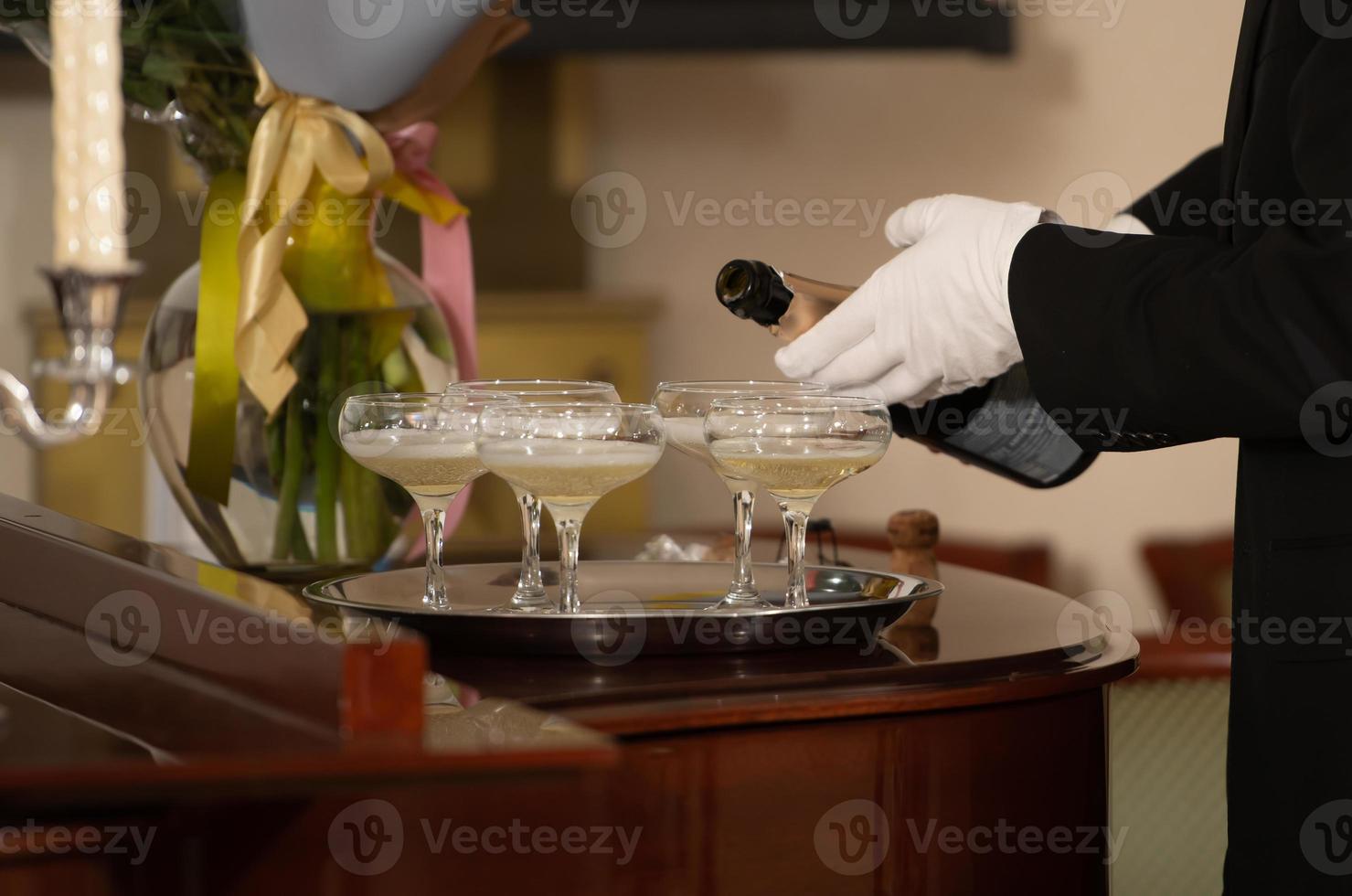 een dienblad met glazen champagne en een fles mousserende wijn. foto