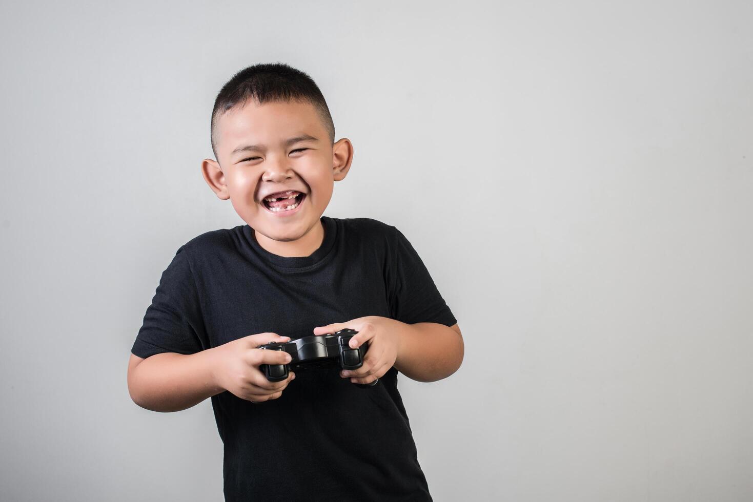 gelukkige jongen speel spelcomputer met een controller in studiofoto foto