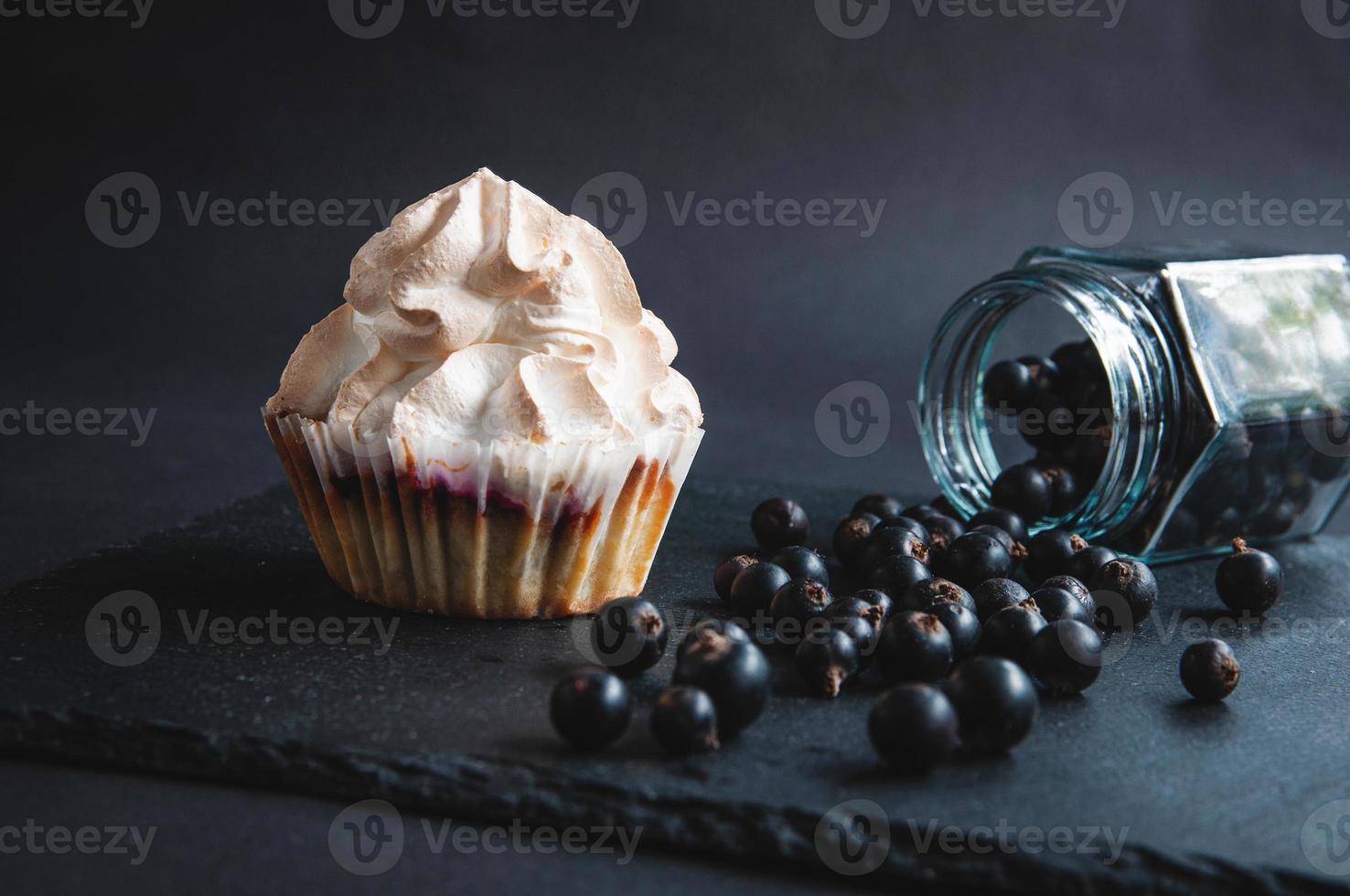 smakelijk gebakken vanille muffin met krenten op een zwart bord. foto