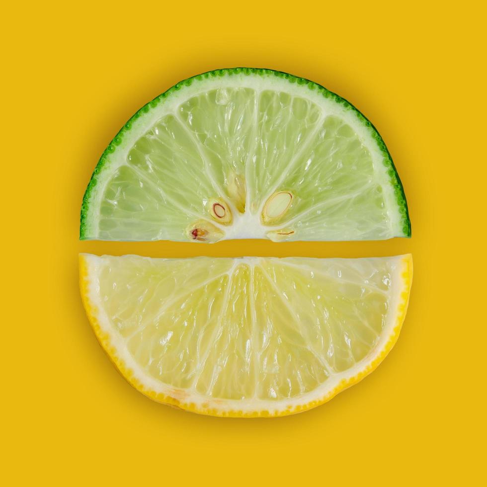schijfje citroen en limoen en verse citrusvruchten op gele achtergrond. foto
