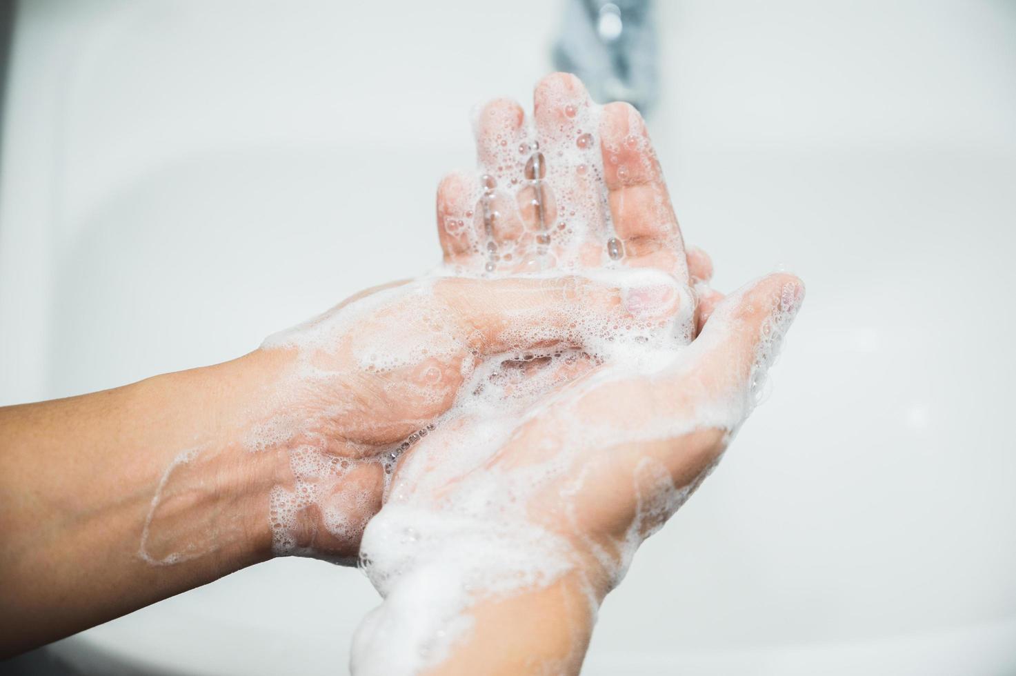 close-up mannelijke handen handen wassen met zeep. foto