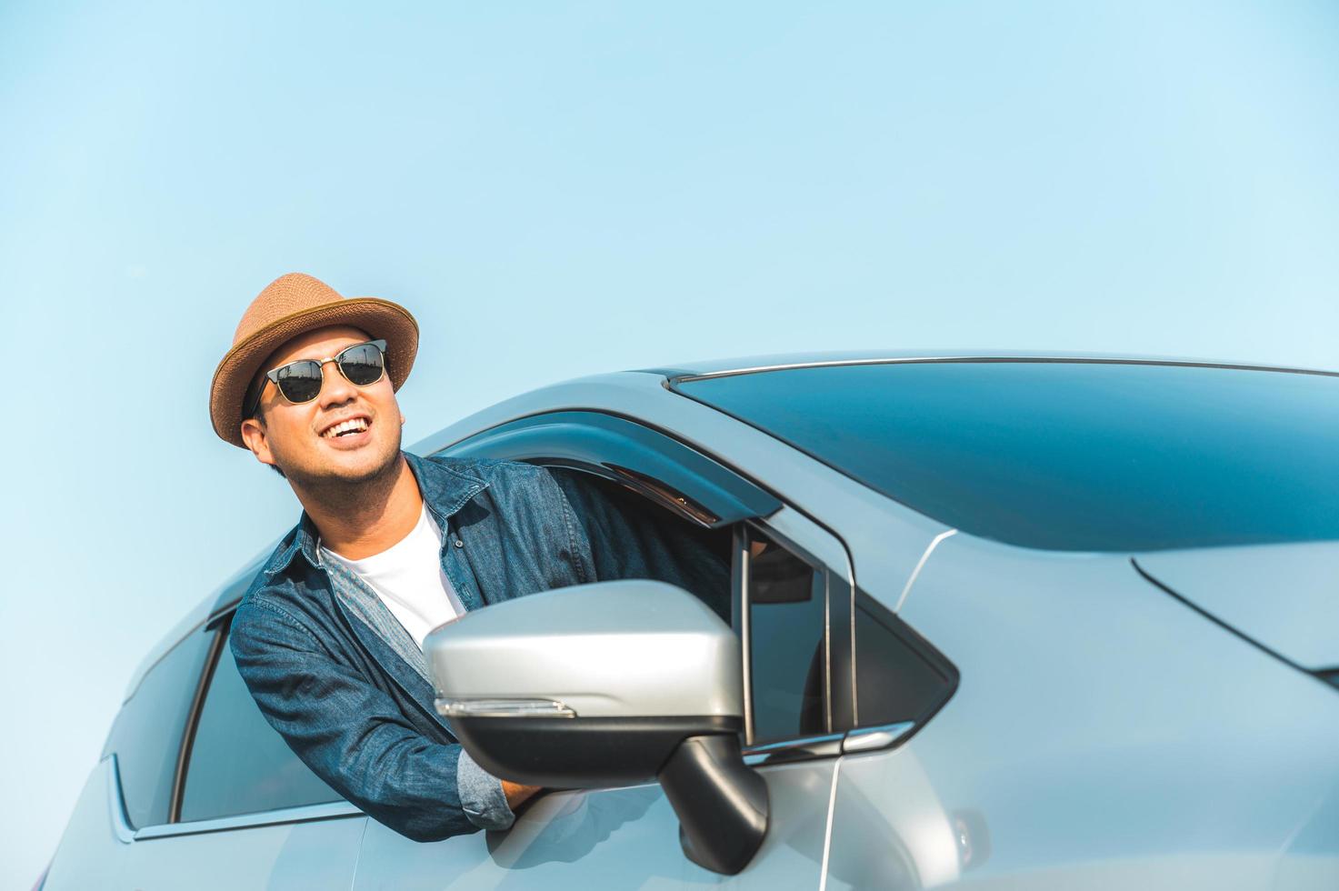 jonge knappe aziatische man die auto rijdt om te reizen foto