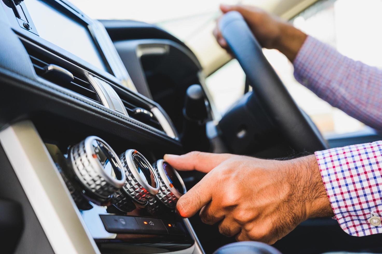 close-up mannenhand controleren airconditioner in de auto. foto