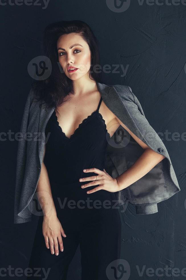 vrouw met donkergrijze jas op zwarte achtergrond foto