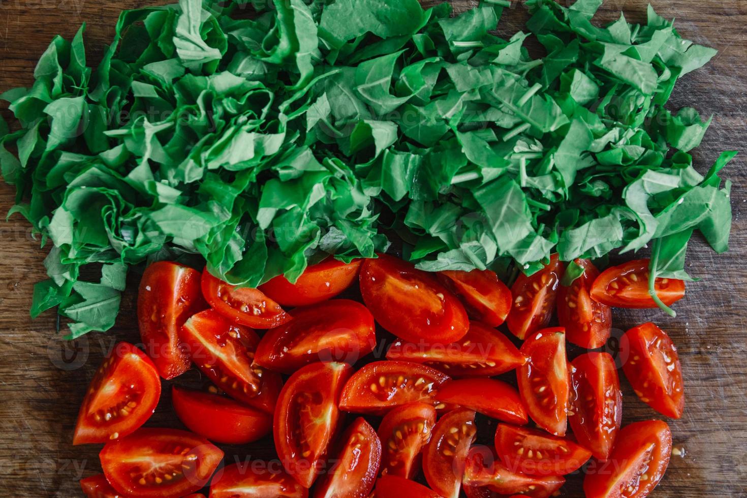 gehakte tomaten en felgroene spinazie op houten rustieke tafel foto