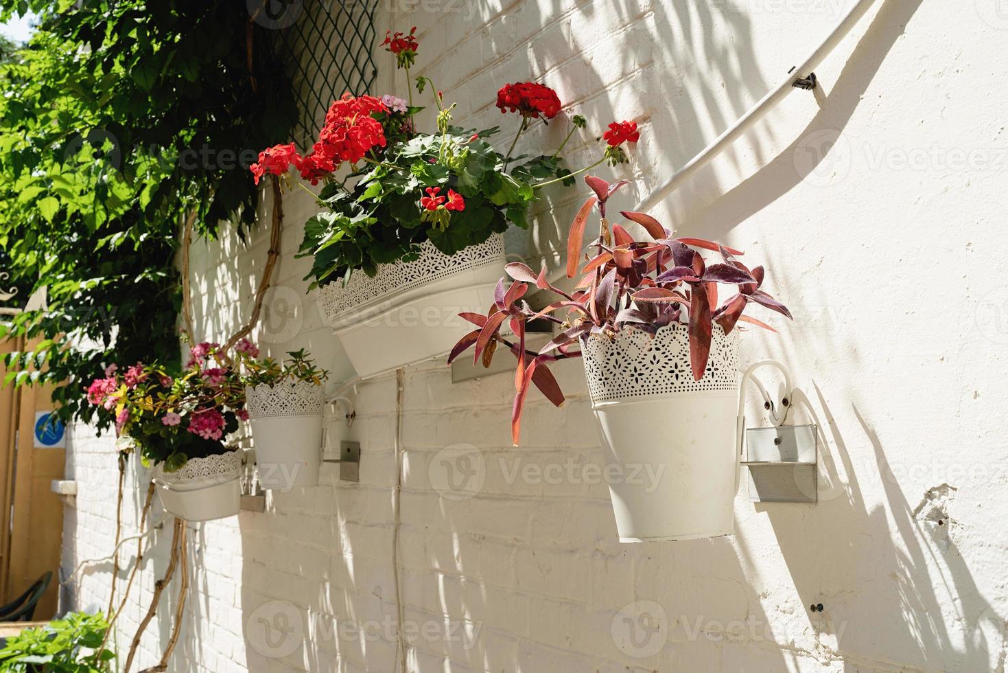 kleurrijke bloemenstraat met witte bakstenen muur in mediterrane stad foto