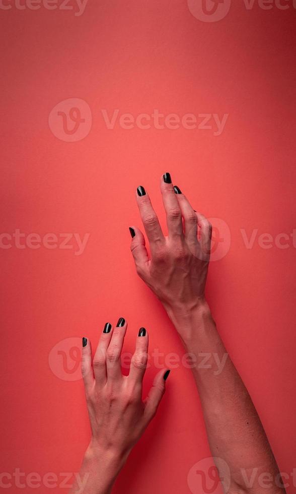 griezelige vrouw halloween handen met zwarte nagels op rode bloedige achtergrond foto