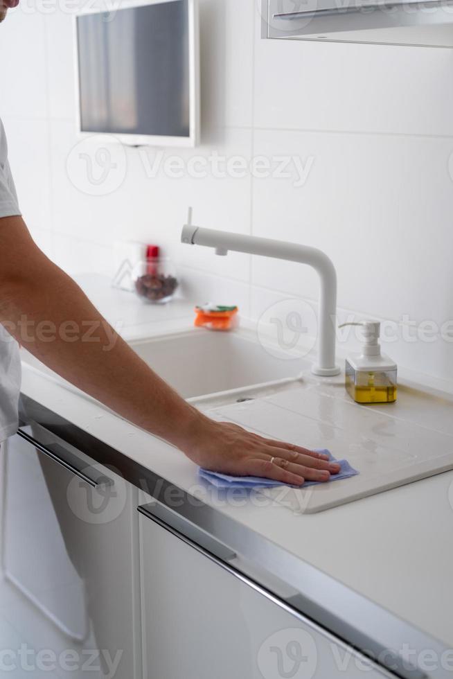 man hand met doek die de keukenoppervlakken schoonmaakt foto