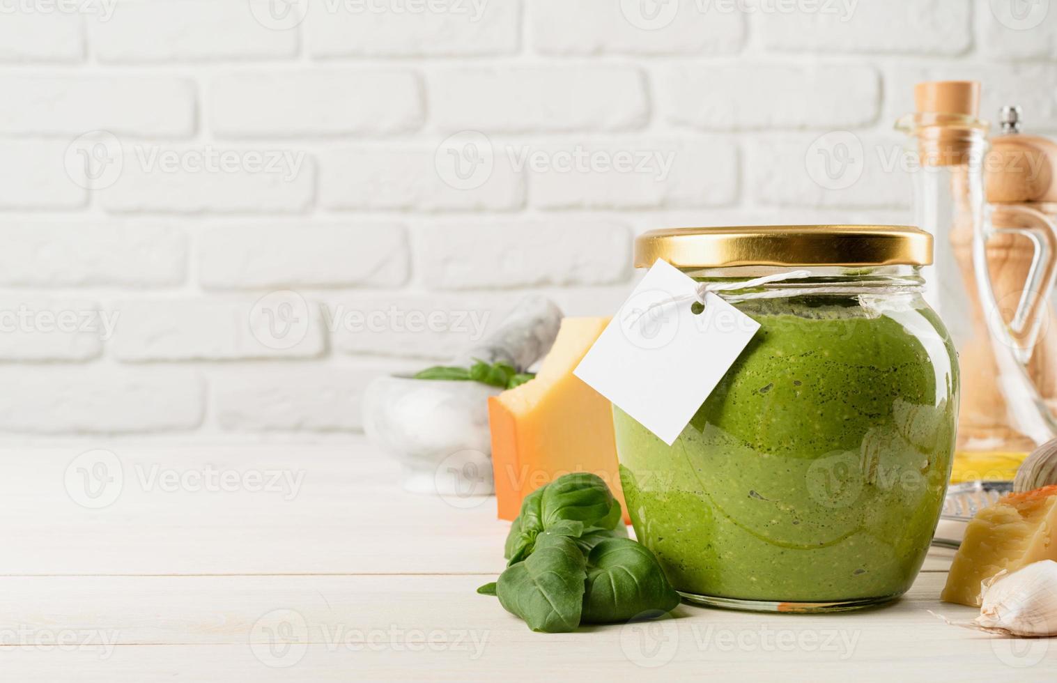 zelfgemaakte pesto-saus in een glazen pot met een blanco tag, mock-upontwerp foto