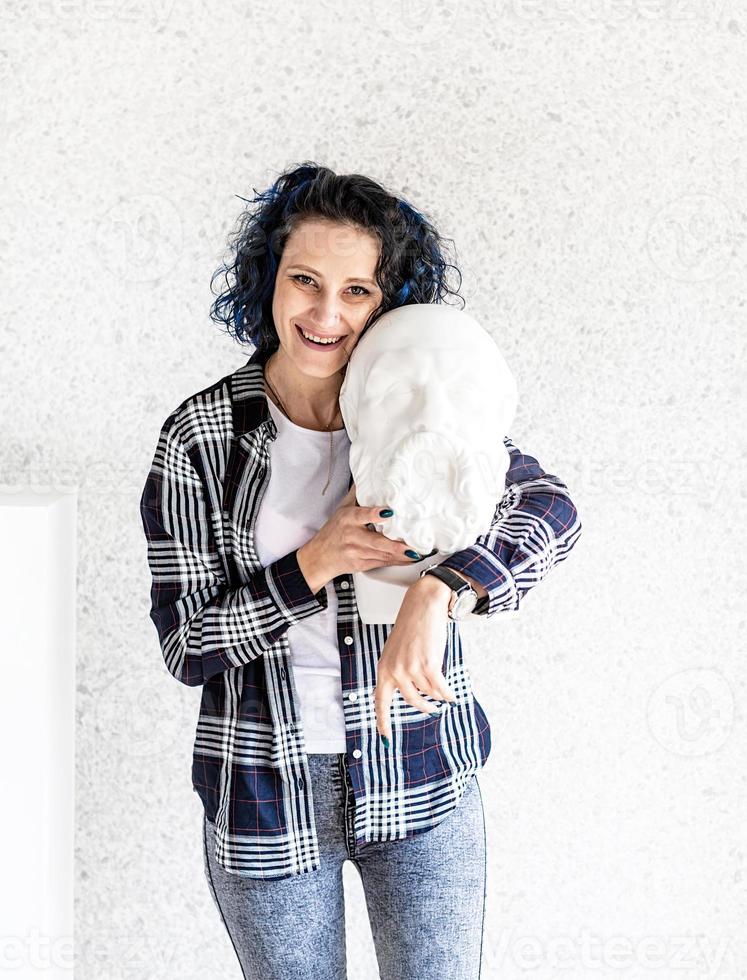 lachende vrouw kunstenaar in haar atelier met gips sculptuur foto