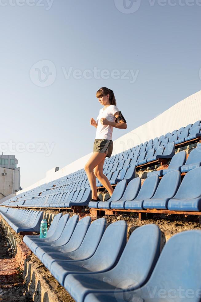 tienermeisje dat aan het trainen is in de staduim die de trap af rent foto