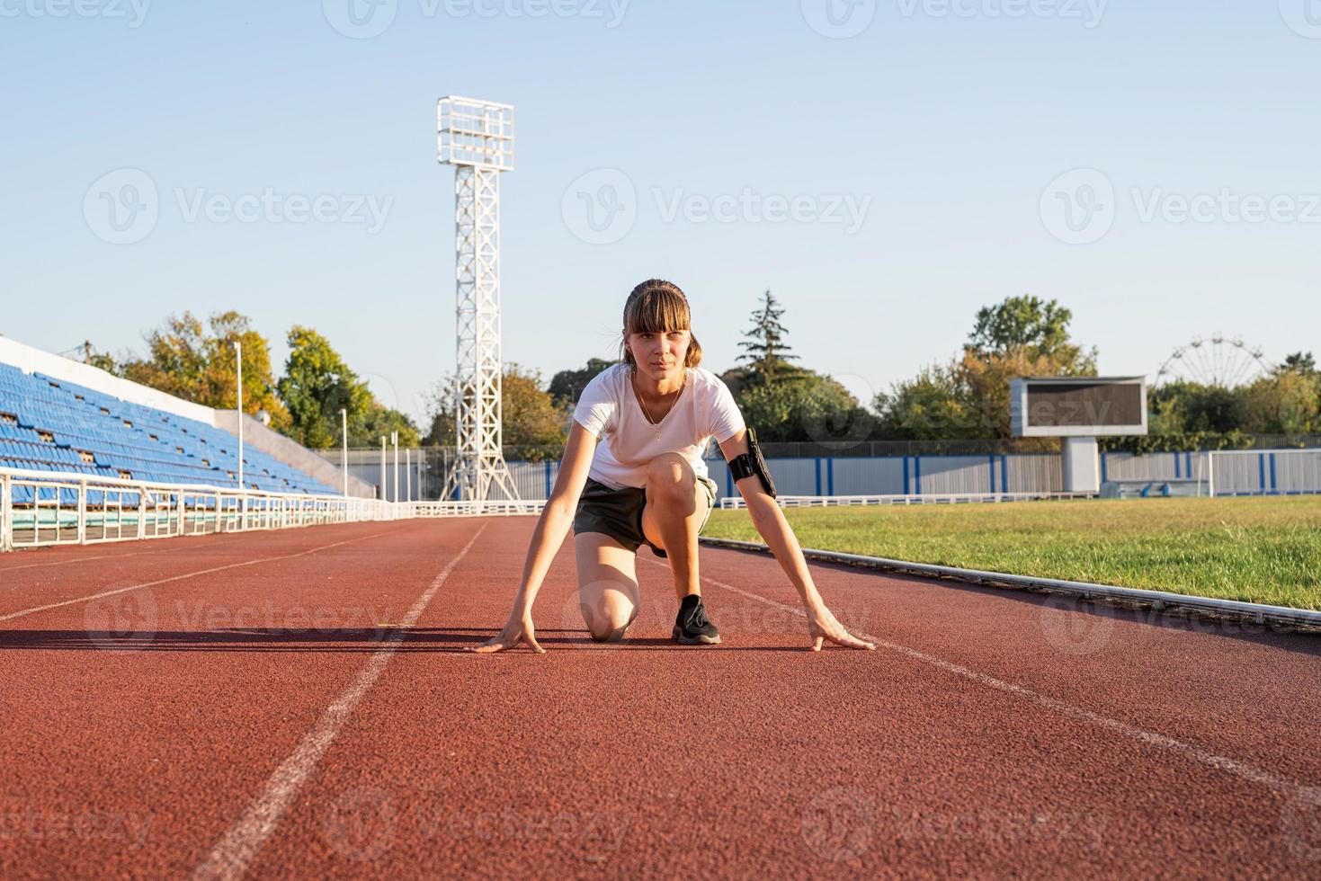 jonge vrouw klaar om te racen op het stadioncircuit foto