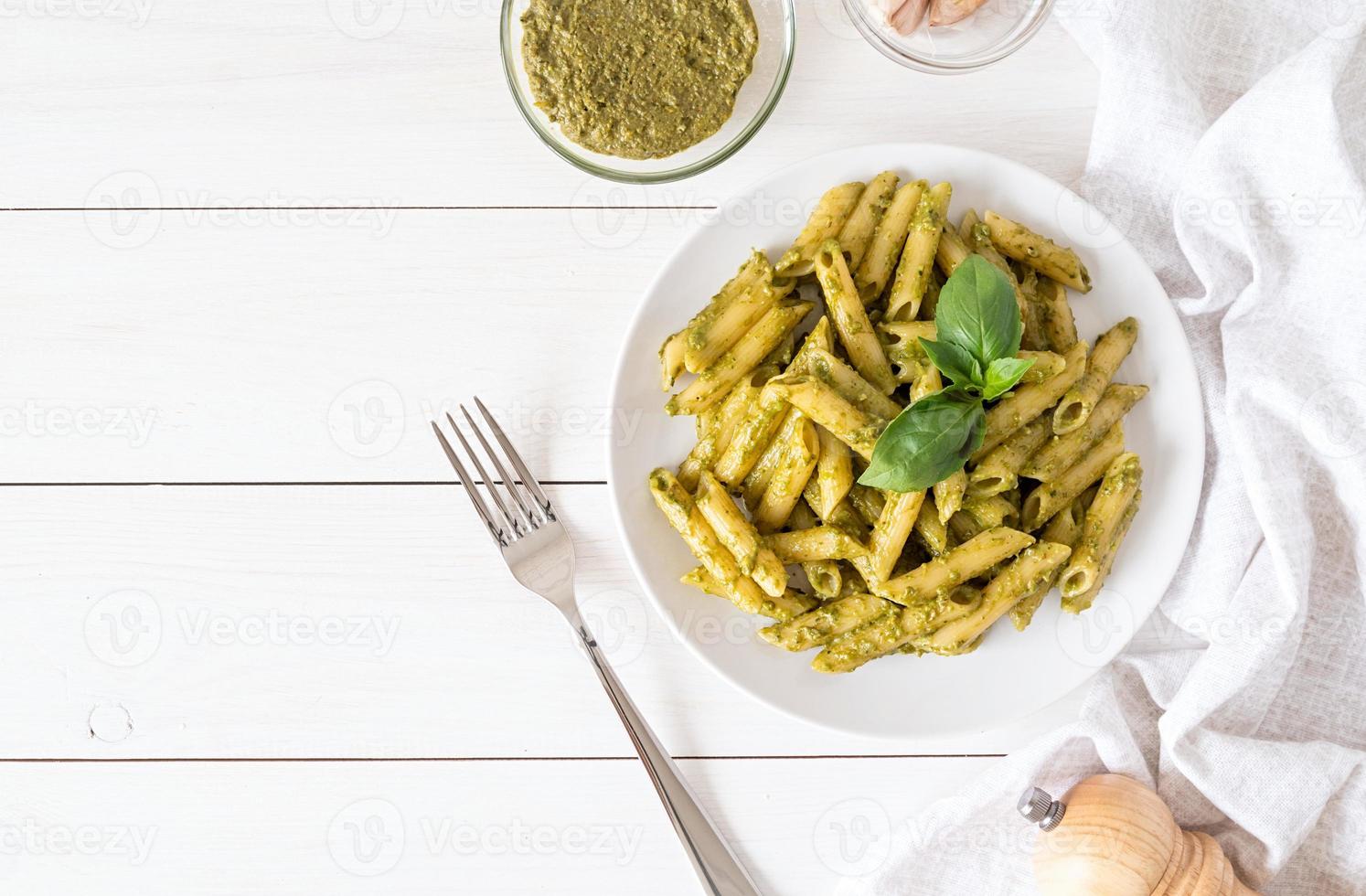 vegan penne pasta in een basilicum pesto saus bovenaanzicht plat liggend foto