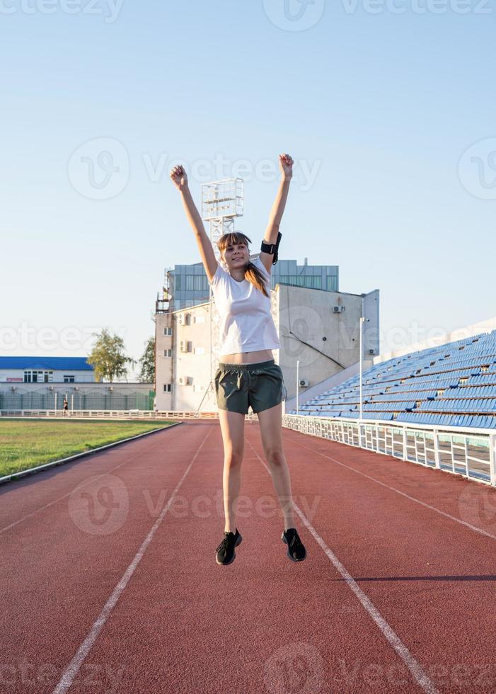 gelukkig sportmeisje dat in het stadion springt foto