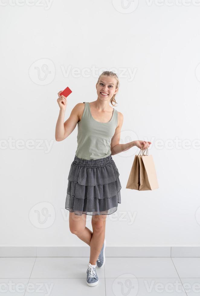 lachende vrouw met milieuvriendelijke boodschappentassen en creditcard foto