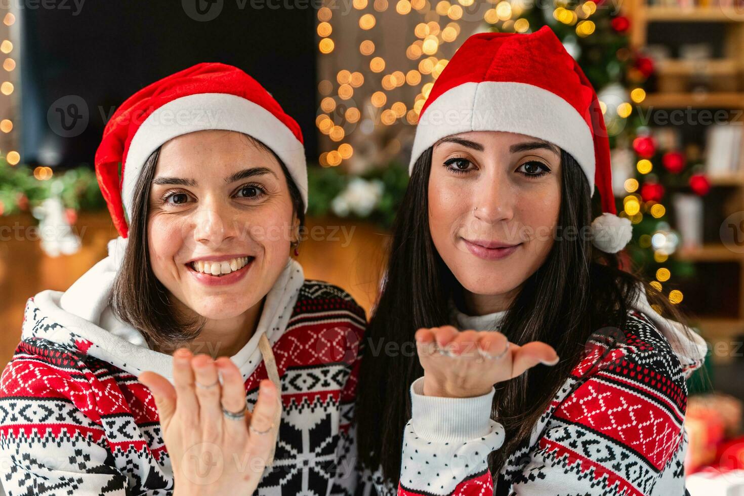 schattig jong Dames gekleed in rood hoed en Kerstmis sweater blazen een kus foto