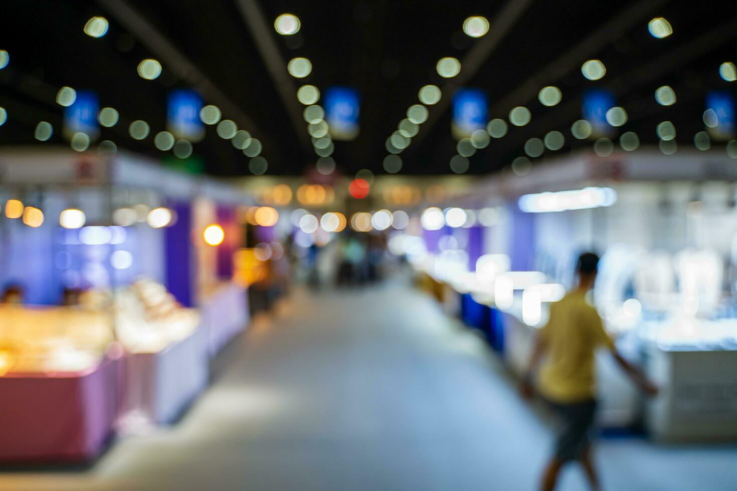 wazig afbeeldingen van handel beurzen in de groot hal. beeld van mensen wandelen Aan een handel eerlijk tentoonstelling of expo waar bedrijf mensen tonen innovatie werkzaamheid en Cadeau producten in een groot hal. foto