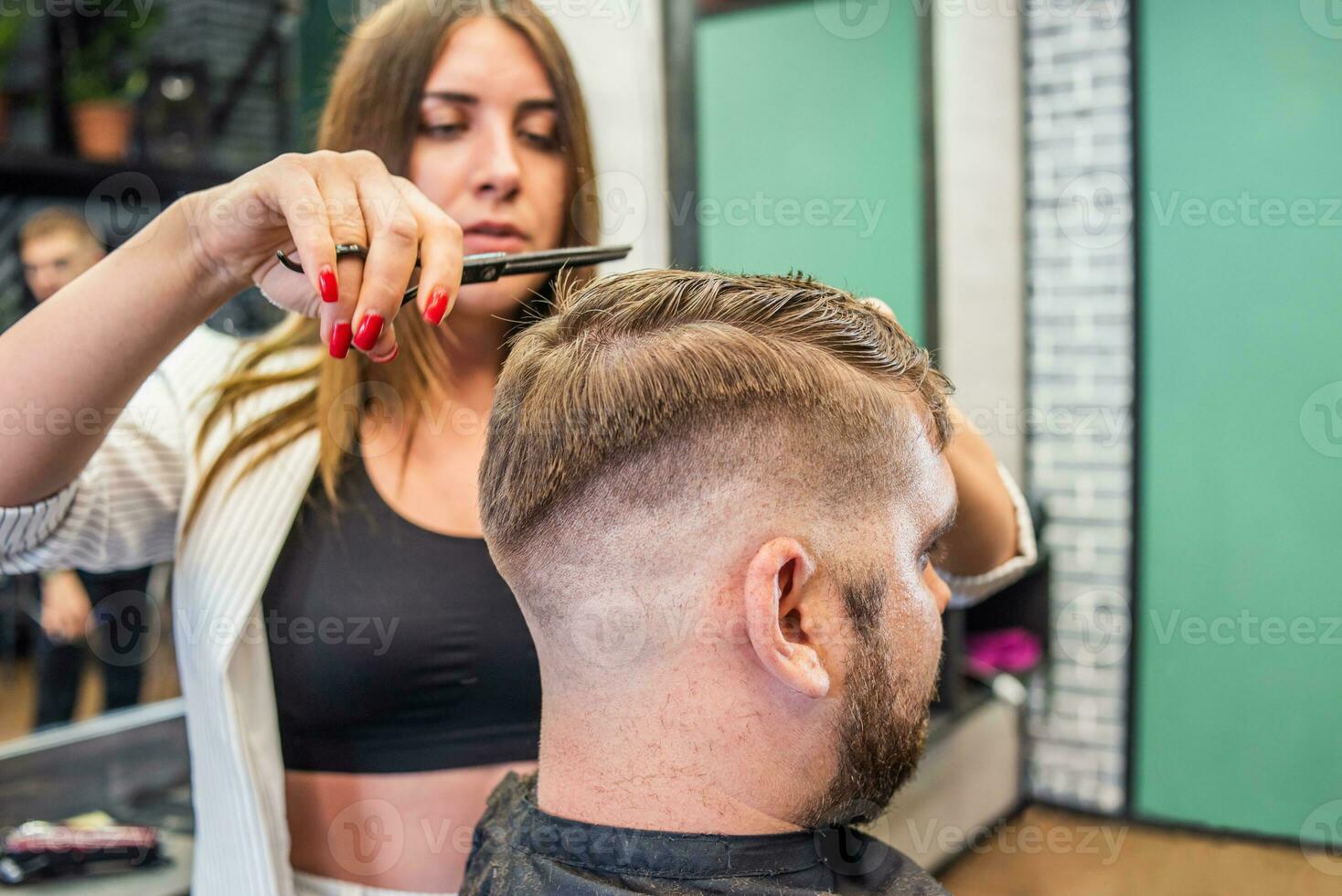 kapper vrouw aan het doen kapsel naar gebaard Mens in kapperszaak foto