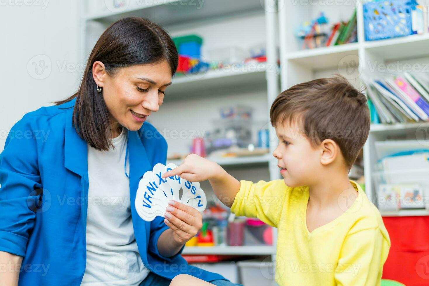 een schattig jongen met een toespraak therapeut is onderwezen naar uitspreken de brieven, woorden en klinkt. foto