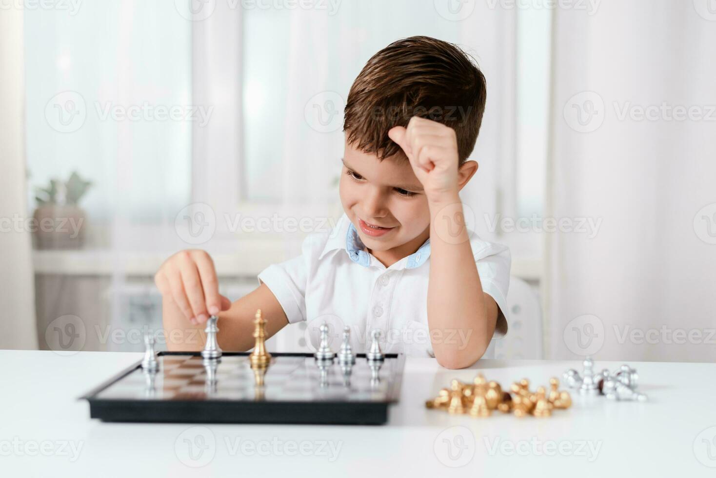 schattig jongen 5 jaren oud Toneelstukken schaak door zichzelf in zijn kamer Bij huis foto