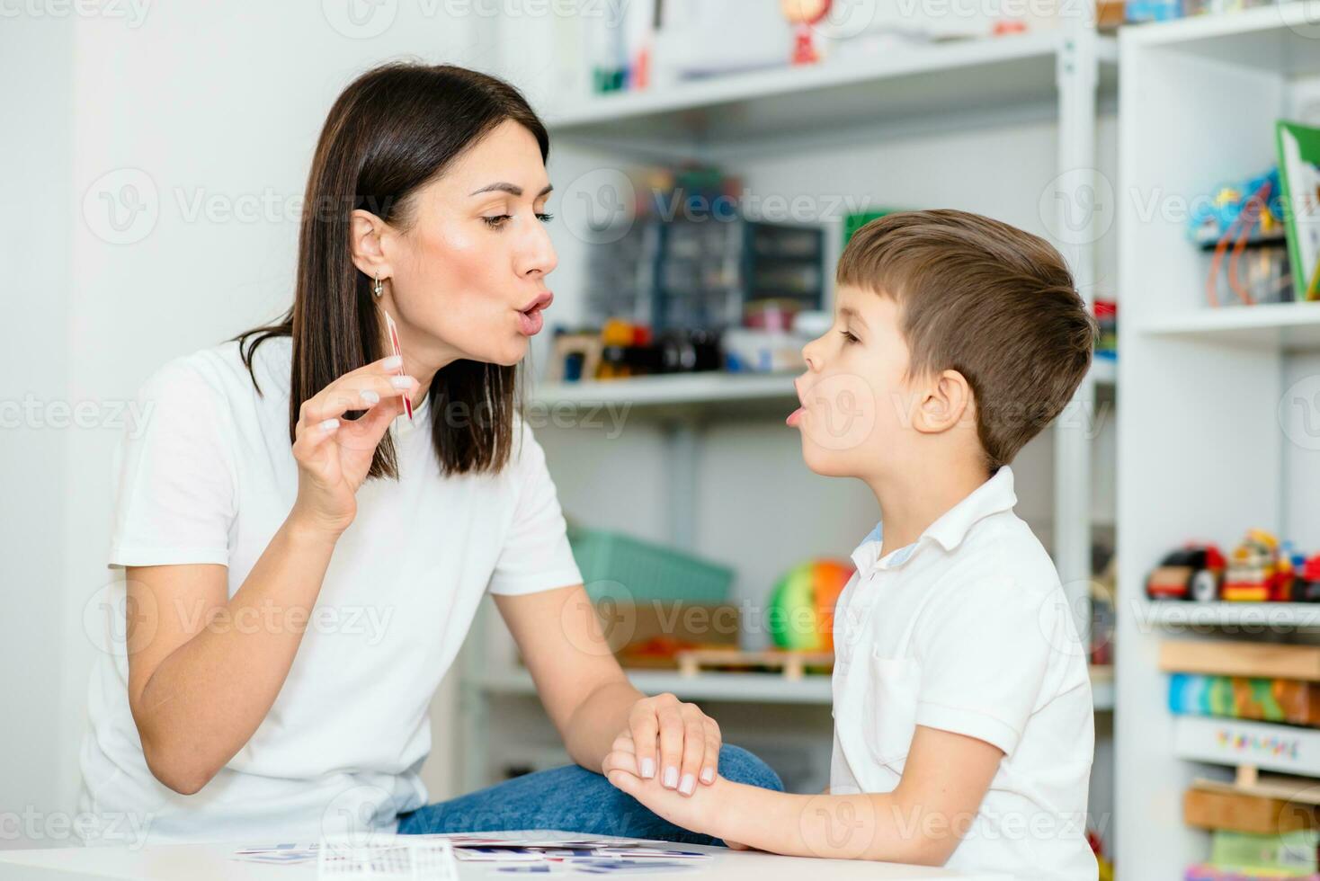 een schattig jongen met een toespraak therapeut is onderwezen naar uitspreken de brieven, woorden en klinkt. foto